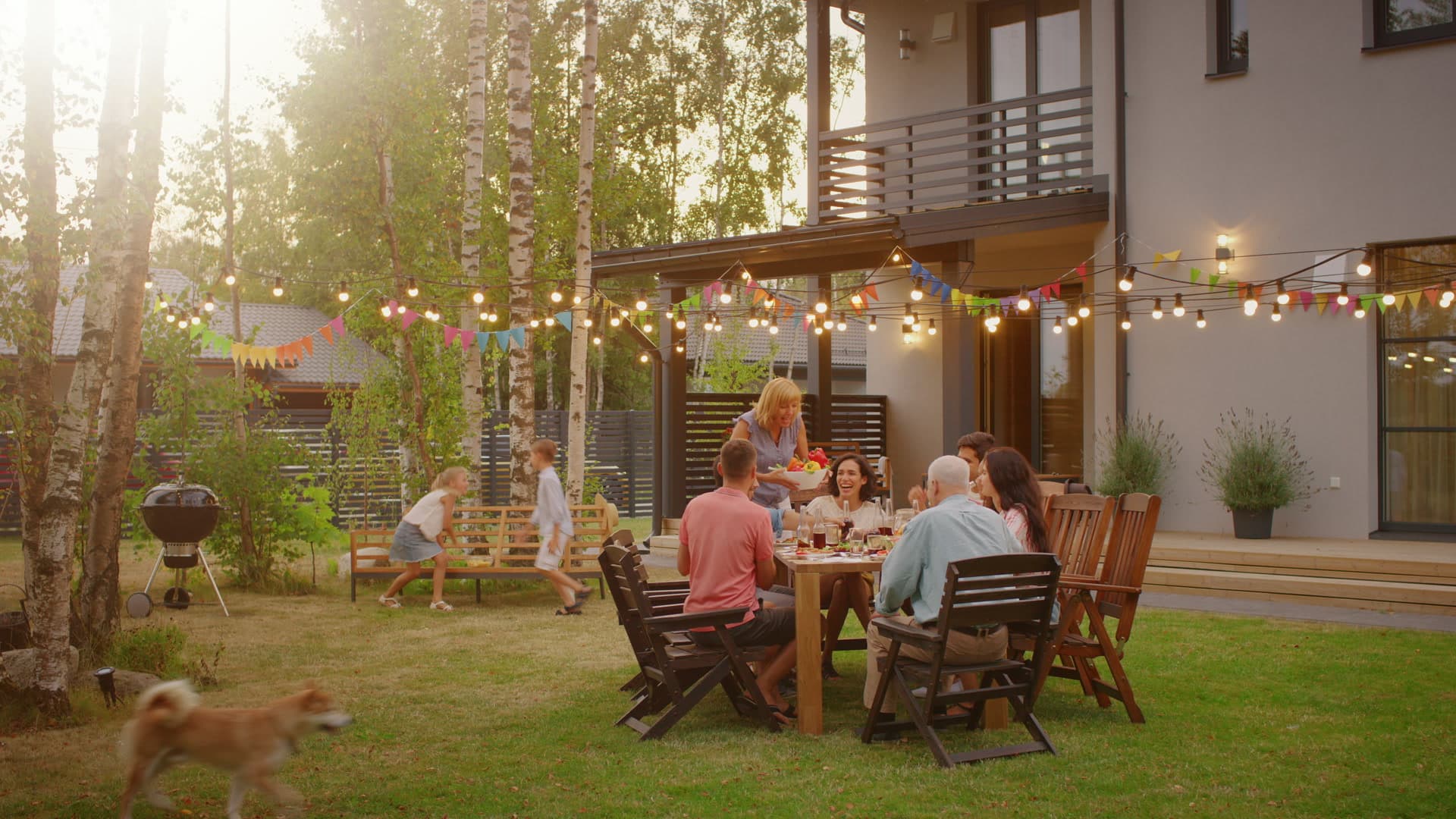 Three generations of a family sharing a meal in the garden at dusk