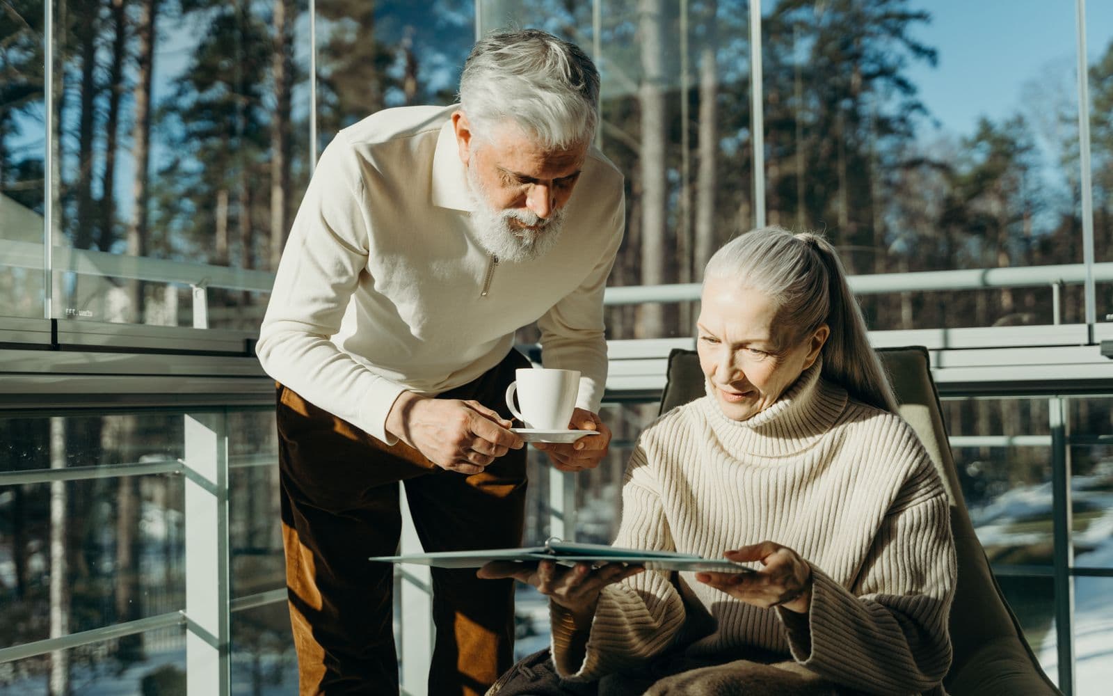 A retired couple sharing coffee on a sunlit balcony, unhurried